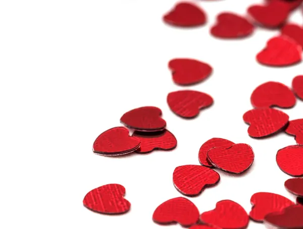 Valentines decoratie van rode confetti hart tegen witte achtergrond met bokeh — Stockfoto