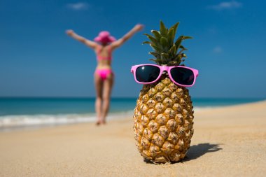 neşeli ananas gözlük ve deniz arka planda sahilde güneşlenirken bir bikini bir kadın. idealist sahne tatil seyahat.