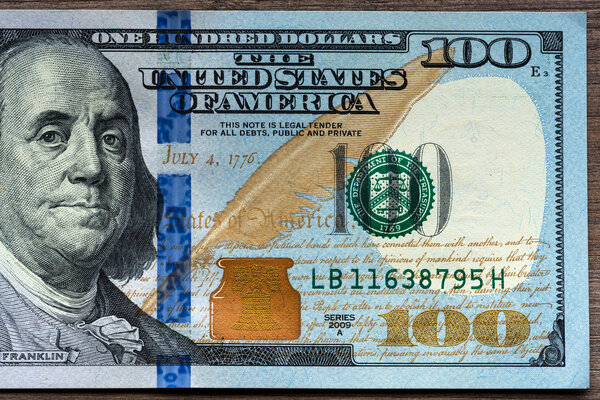 New hundred Dollar Bills on wooden background