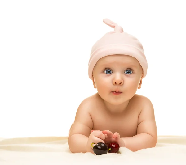 Pequeño bebé está mirando a la cámara y lleva un sombrero en el fondo blanco —  Fotos de Stock