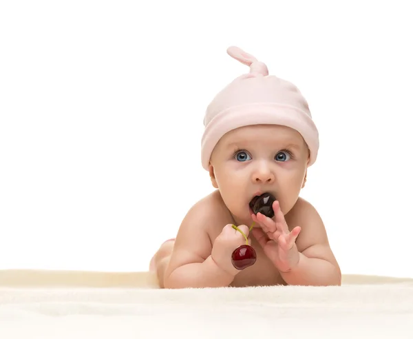 Lilla bebis tittar in i kameran och bär en hatt på den vita bakgrunden — Stockfoto