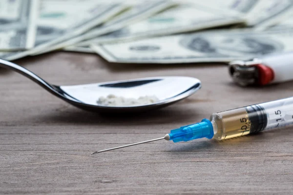 Drug syringe, cooked heroin on spoon and money — Stock Photo, Image