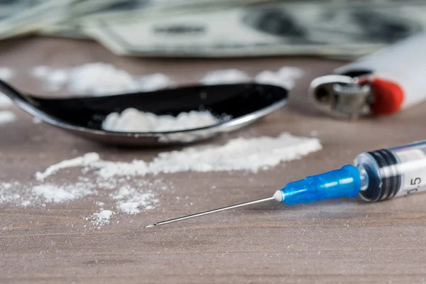 Drug syringe, cooked heroin on spoon and money — Stock Photo, Image