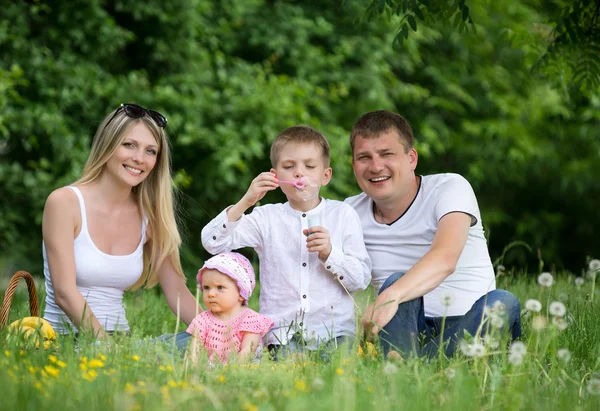 Porträtt av lycklig familj i trädgården — Stockfoto