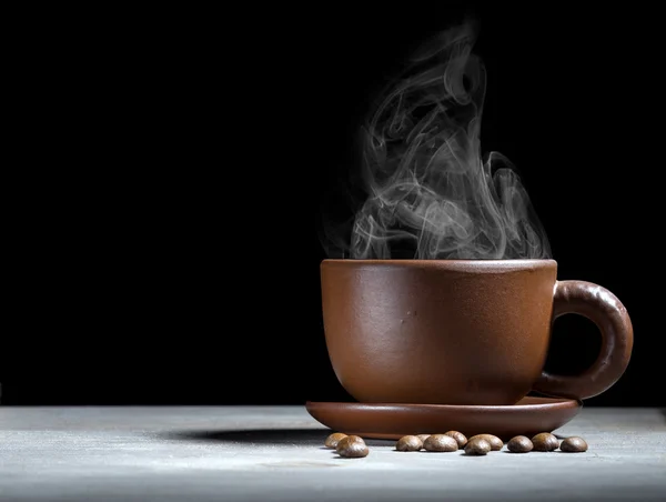 Steaming coffee cup on dark background