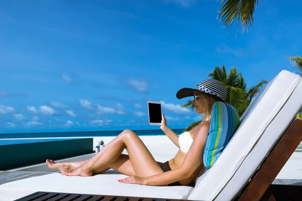Mujer joven en sombrero con tablet pc en la playa —  Fotos de Stock