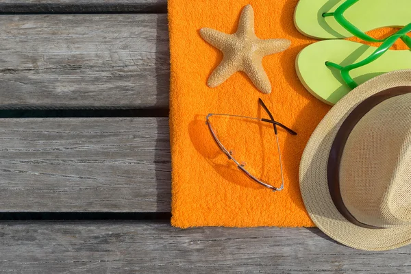 Zapatillas de playa, toalla y gafas de sol sobre fondo de madera. Concepto de ocio y viajes —  Fotos de Stock