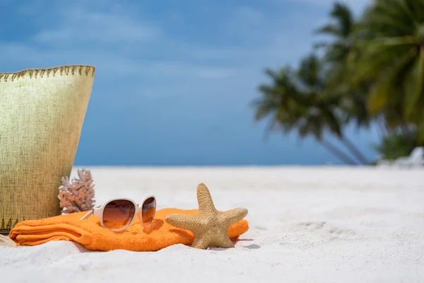 Summer beach bag with starfish,towel,sunglasses and flip flops on sandy beach — Stock Photo, Image
