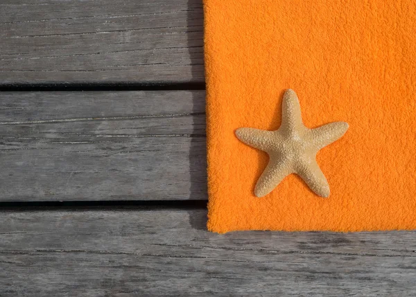 Beach towel and starfish on wood background. Concept of leisure and travel — Stock Photo, Image