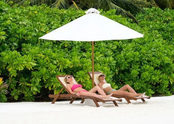 Belle ragazze rilassarsi su una sedia a sdraio vicino al mare — Foto Stock