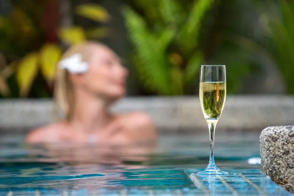 Champagne vicino alla piscina su uno sfondo di una bella donna relax — Foto Stock