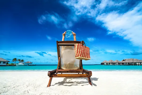 Young girl lying on a tropical beach and mask for diving — Stock Photo, Image