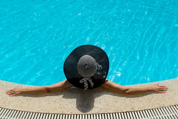 戴帽子的女人在游泳池边放松 — 图库照片