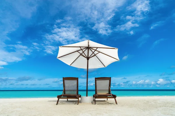 Beach lounger and umbrella on sand beach. Concept for rest, relaxation, holidays, spa, resort. — Stock Photo, Image