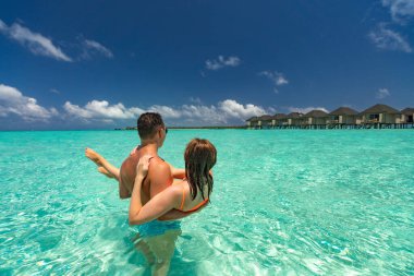 Yaz tatilinde tropikal plajda genç mutlu çift.