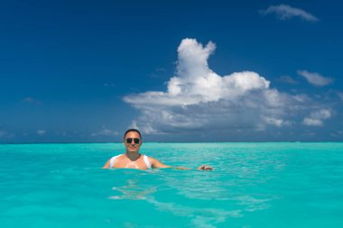 Adam güneşleniyor ve sahilde dinleniyor. Kaslı adam için yaz tatili.