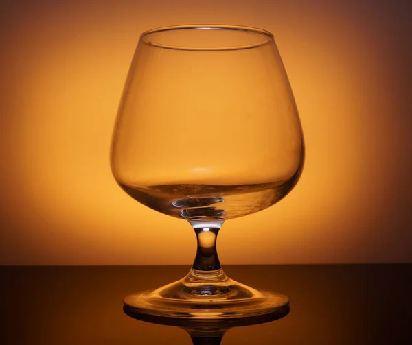 Transparent glass goblet on yellow background — Stock Photo, Image