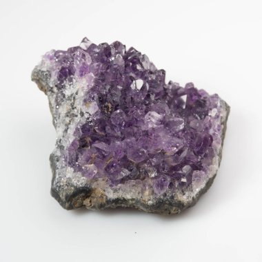 Beyaz zemin üzerinde doğal menekşe ametist druse kümesi