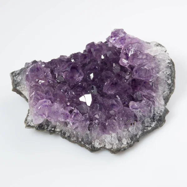 Beyaz zemin üzerinde doğal menekşe ametist druse kümesi