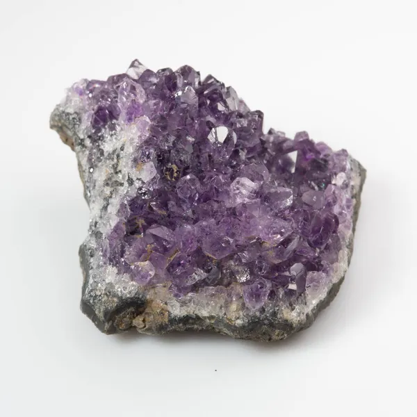 Beyaz zemin üzerinde doğal menekşe ametist druse kümesi