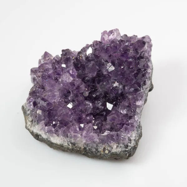 Beyaz zemin üzerinde doğal menekşe ametist druse kümesi