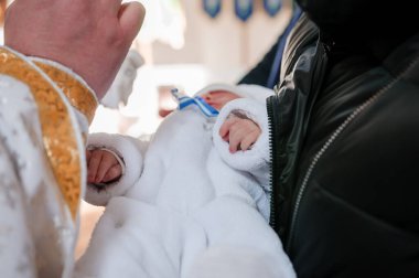 Vaftiz töreni. Rahip, çocuğu vaftiz töreniyle vaftiz ediyor.