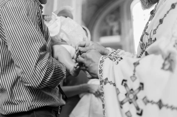 Таинство крещения священник крестит ребенка помазанием — стоковое фото