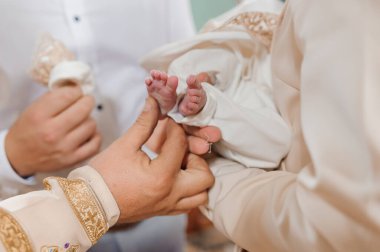 Vaftiz töreninde rahip çocuğu vaftiz ederek vaftiz eder.