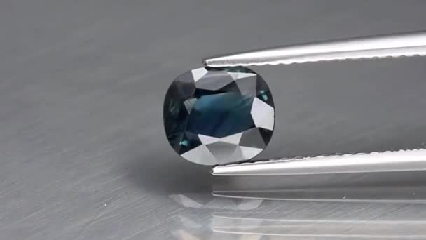 Натуральный синий сапфировый драгоценный камень в пинцетах — стоковое видео