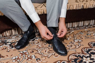 Bir adam yakın plan siyah ayakkabı giyiyor.