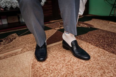 Bir adam yakın plan siyah ayakkabı giyiyor.