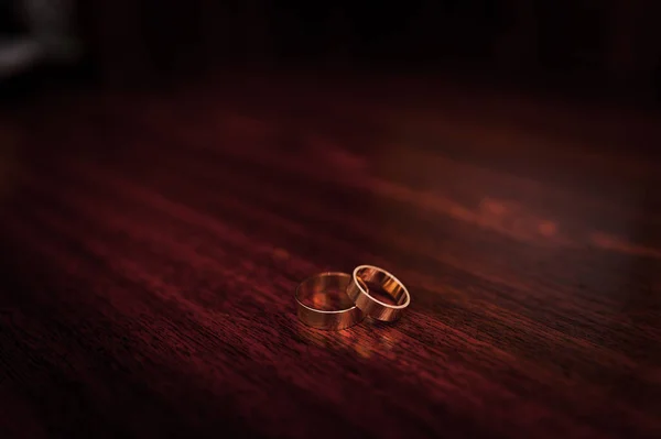 Zwarte strik, bruiloft gouden ringen op bruine houten achtergrond — Stockfoto