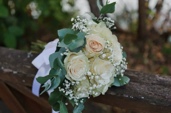 Свадебный букет свежих цветов, пара золотых колец крупным планом. Свадебные детали — стоковое фото