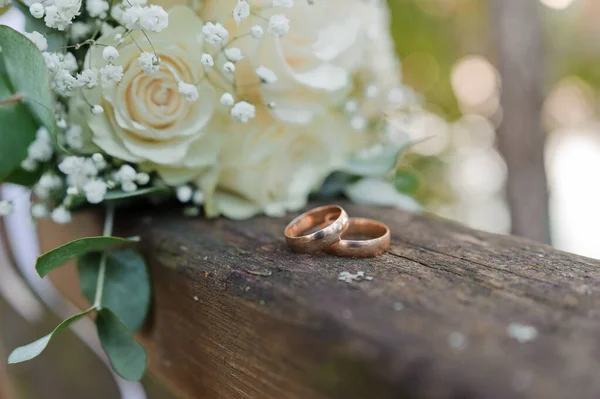 Esküvői csokor friss virágokkal, egy pár arany gyűrűvel közelről. Esküvői adatok — Stock Fotó