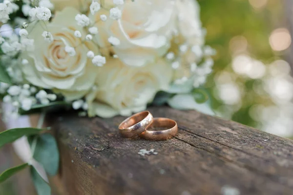 Esküvői csokor friss virágokkal, egy pár arany gyűrűvel közelről. Esküvői adatok — Stock Fotó