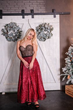 Noel ağacının arka planında duran çok güzel elbiseli kız.