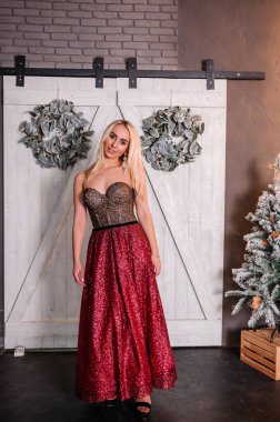 Noel ağacının arka planında duran çok güzel elbiseli kız.