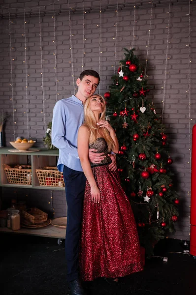 A girl in a beautiful dress hugs and kisses a guy. New Years photo session — Stock Photo, Image