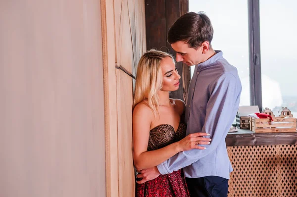 A girl in a beautiful dress hugs and kisses a guy. New Years photo session — Stock Photo, Image