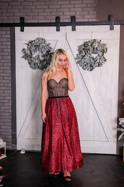 Noel ağacının arka planında duran çok güzel elbiseli kız.