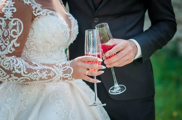 Νύφη και γαμπρός κρατώντας ένα ποτήρι κόκκινο κρασί — Φωτογραφία Αρχείου