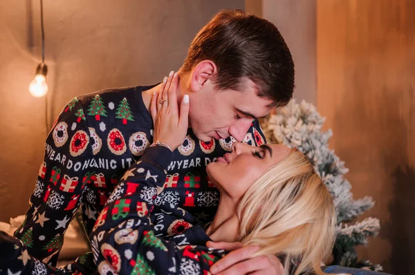 Kazaklı ve kot pantolonlu bir kız yatakta uzanıp sarılıyor.