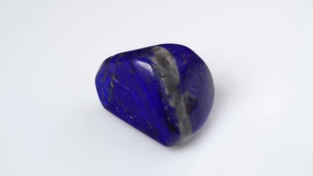 Piedra de gema lapislázuli azul natural sobre el fondo blanco — Vídeos de Stock