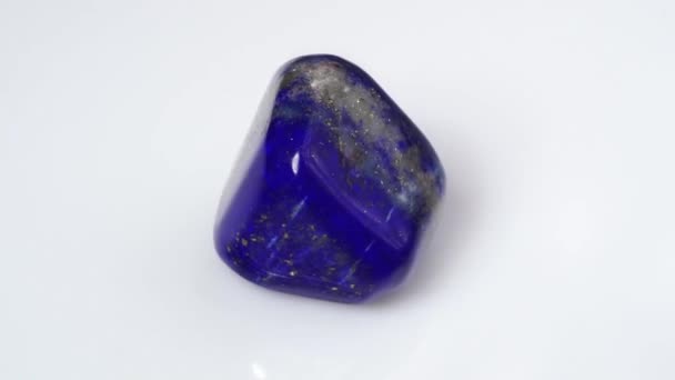 Natuurlijke blauwe lapis lazuli edelsteen op de witte achtergrond — Stockvideo