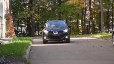 SUV, binanın yanındaki asfalt sokaktan geçiyor.