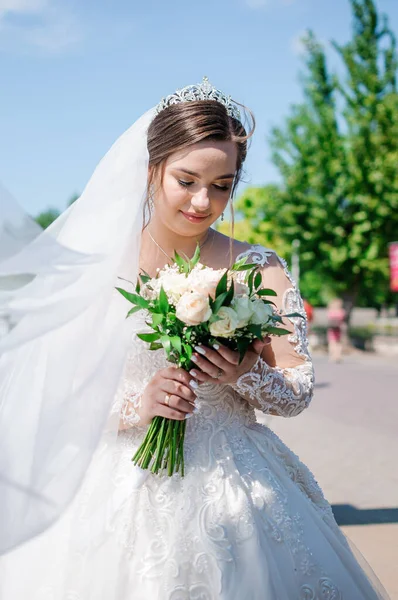Potret pengantin wanita dengan gaun putih yang indah dengan latar belakang hijau. Pengantin dengan karangan bunga — Stok Foto