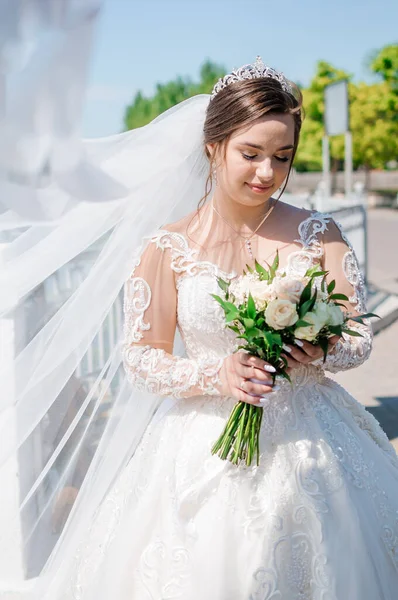 Potret pengantin wanita dengan gaun putih yang indah dengan latar belakang hijau. Pengantin dengan karangan bunga — Stok Foto