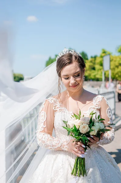 Potret pengantin wanita dengan gaun putih yang indah dengan latar belakang hijau. Pengantin dengan karangan bunga — Stok Foto