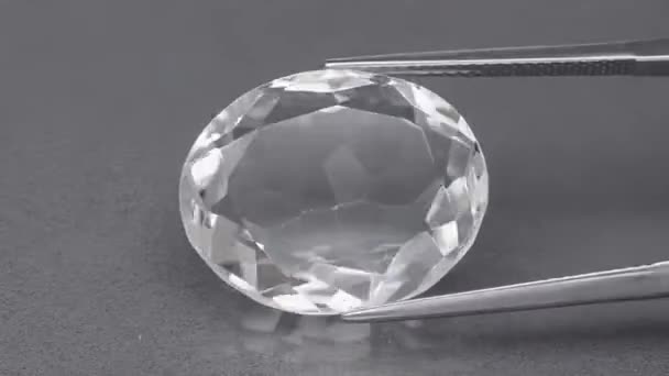 Piedra de gema de cuarzo blanco natural en la mesa giratoria en pinzas — Vídeos de Stock
