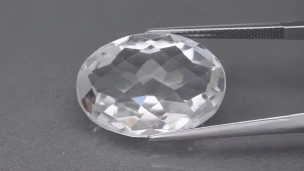 Природный белый кварцевый камень на поворотном столе в пинцетах — стоковое видео